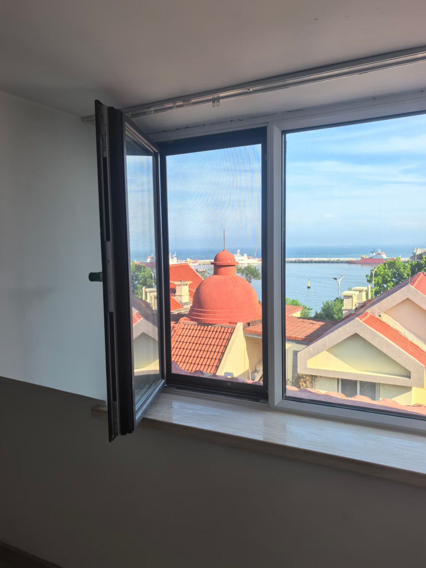 青岛海景房白框系统窗完工实拍，窗外可见海港全景